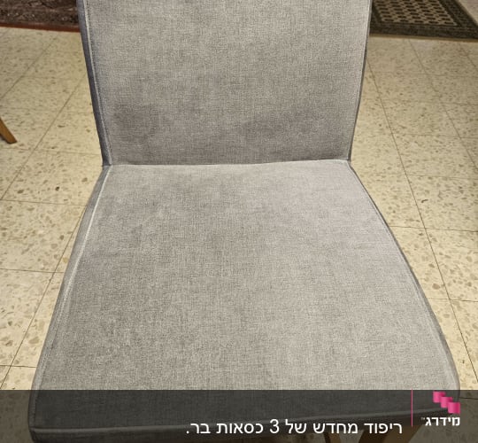 כיסא מרופד בבד אפור על רצפת אריחים